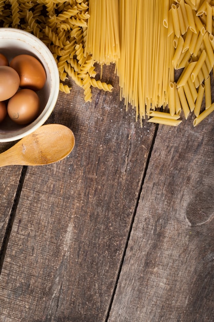 Espaguete macarrão com farinha, ovo na madeira velha