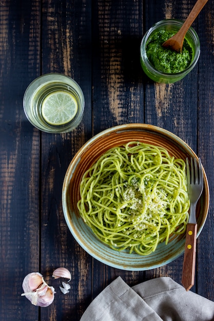 Espaguete macarrão com molho pesto em uma mesa de madeira. Cozinha nacional. Alimentação saudável. Comida vegetariana. Receita.