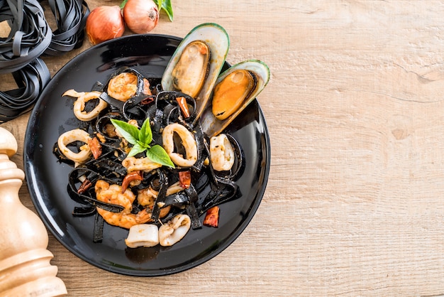 Foto espaguete preto ou macarrão com frutos do mar