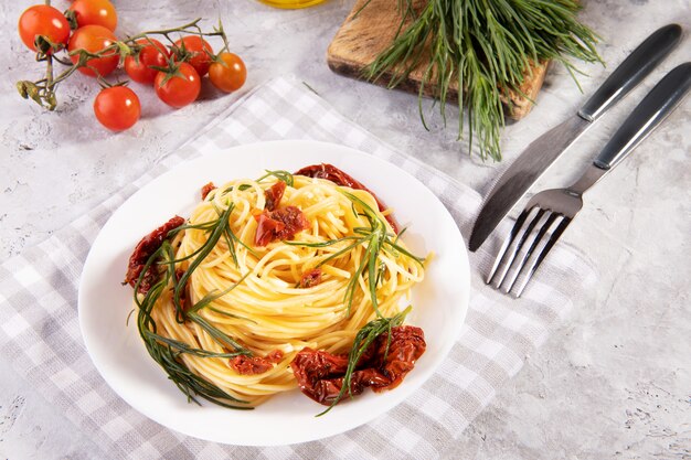 Espagueti con agretti, un vegetal de primavera de Italia y tomates secados al sol