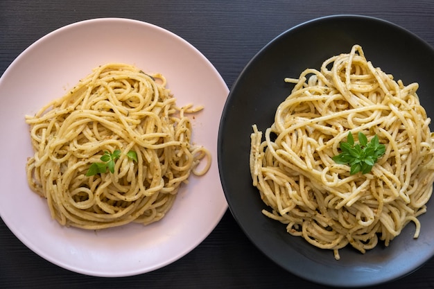 espagueti cremoso en un plato rosa y negro