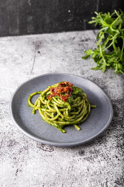 Foto espagueti de gragnano con pesto casero y tomates secos plato adecuado para adultos y niños saludable y sabroso