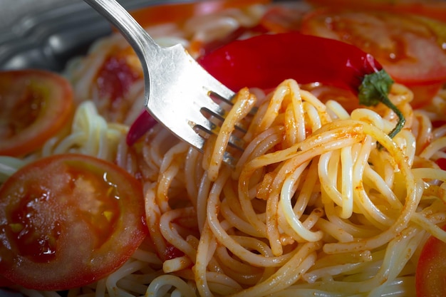 Foto espagueti hervido con condimentos y verduras sobre un fondo viejo