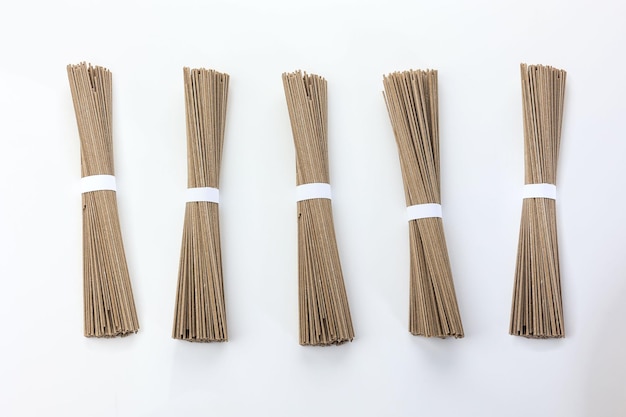 Espagueti de pasta de fideos de trigo sarraceno crudo sobre fondo blanco