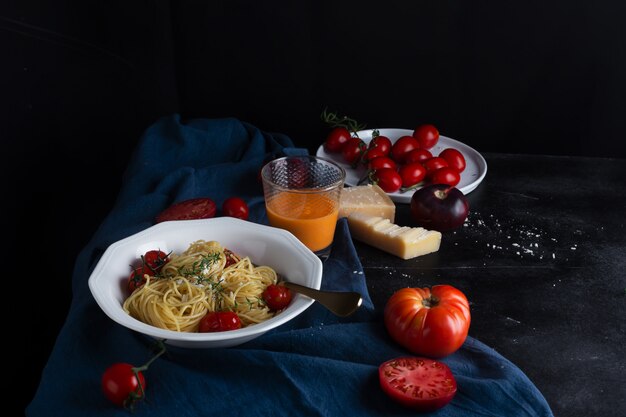 Espagueti de pasta italiana con tomate cherry frito y tomillo, vista lateral