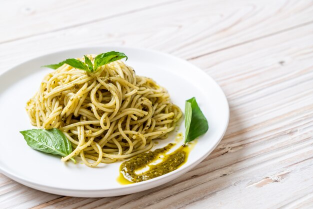 espagueti con salsa de pesto, aceite de oliva y hojas de albahaca.