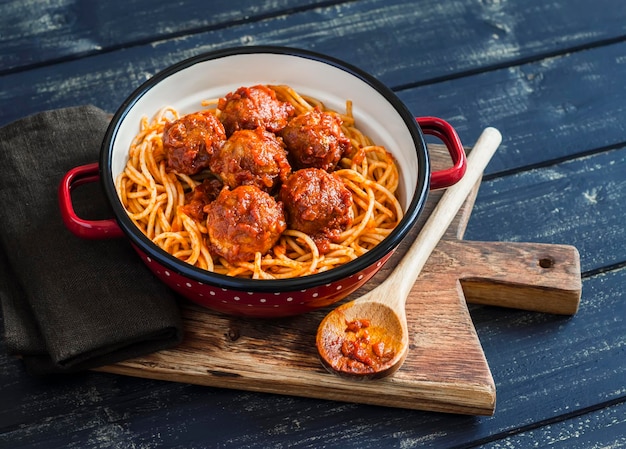 Espaguetis y albóndigas en salsa de tomate sobre tabla rústica de madera Delicioso almuerzo