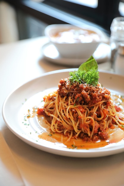 Espaguetis a la boloñesa con carne picada y salsa de tomate aderezado con queso parmesano y albahaca, comida italiana