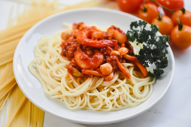 Espaguetis a la boloñesa pasta italiana con camarones gambas servido en plato blanco con tomate perejil en el restaurante comida italiana y concepto de menú