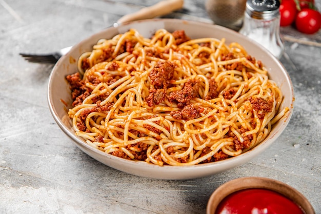 Espaguetis a la boloñesa con tomates cherry en la mesa