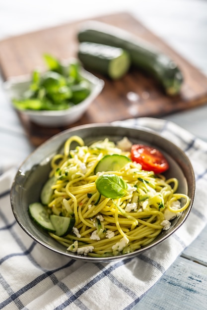 Espaguetis de calabacín, pasta cruda vegana con queso feta, pepino y albahaca.