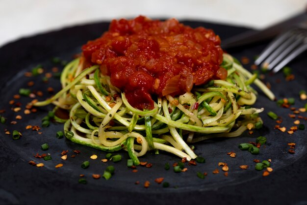 Espaguetis de calabacín con pepperoni deshidratado y salsa roja.