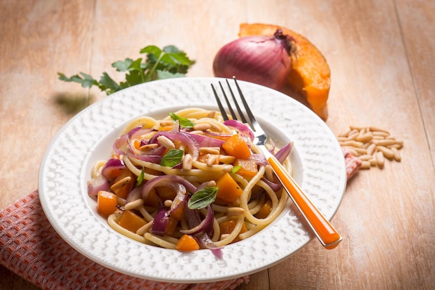 Espaguetis con calabaza, cebolla y perejil, enfoque selectivo