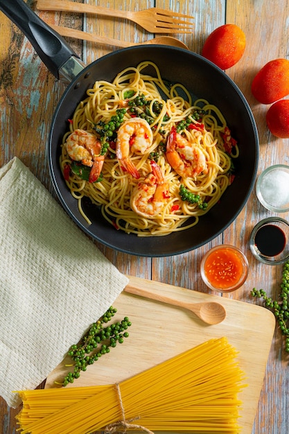 Espaguetis de camarones en una sartén, langostinos fritos Pasta de espagueti italiana en plato de cerámica con fresco