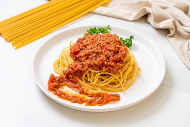 espaguetis de cerdo a la boloñesa o espaguetis con salsa de tomate de cerdo picada - estilo de comida italiana