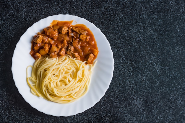 Espaguetis con cerdo en salsa de tomate. Comida sabrosa