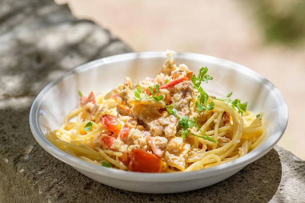 Espaguetis cocidos frescos con cangrejo de mar marrón comestible también conocido como Cancer Pagurus por el mar Mediterráneo en plato blanco