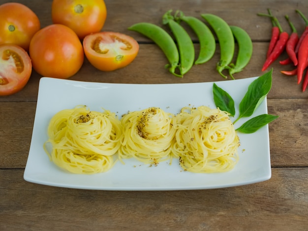 Foto espaguetis cocidos maduros de la pasta en la placa blanca