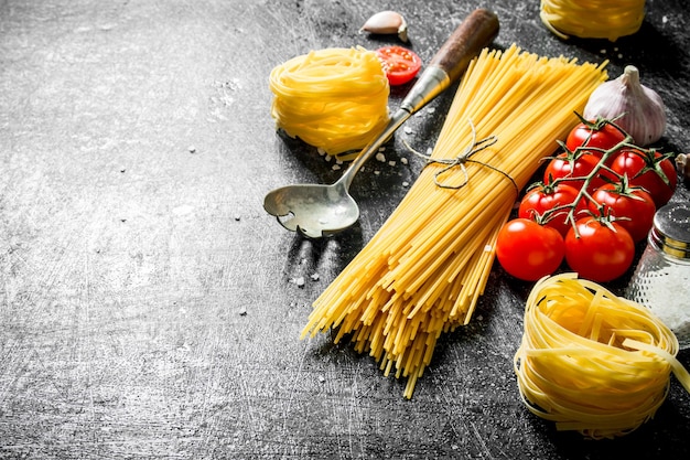 Espaguetis crudos y tagliatelle con tomates cherry, ajo y un cucharón