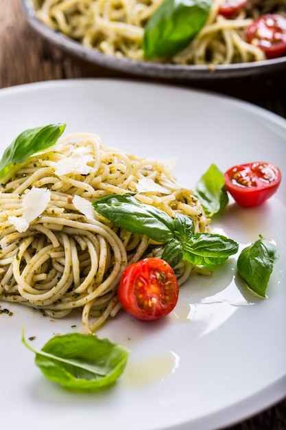Espaguetis. Espaguetis de pasta italiana con pesto de albahaca, tomates cherry y aceite de oliva.