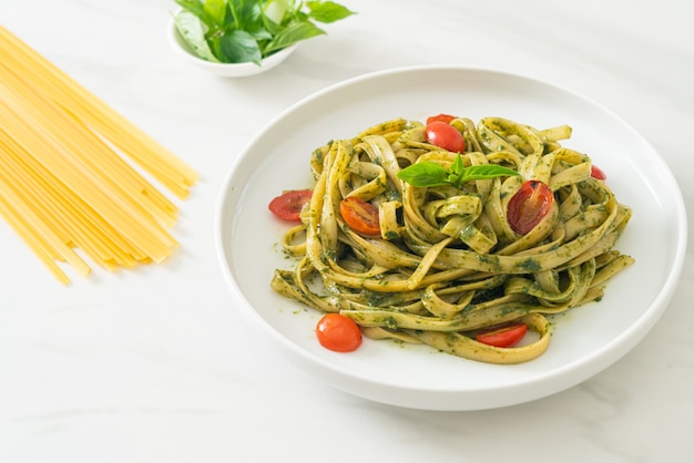 espaguetis fettuccine con salsa pesto y tomates - estilo de comida vegana y vegetariana