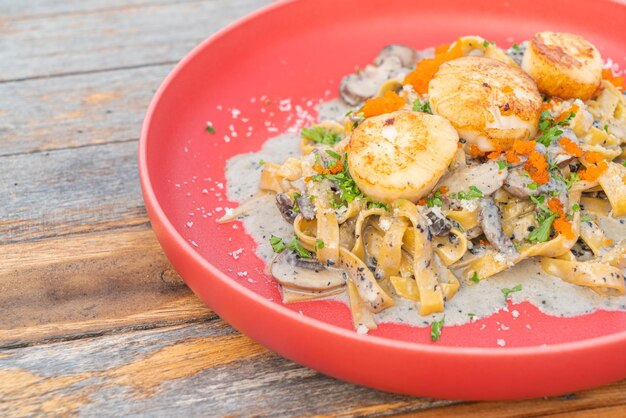 espaguetis fettuccini con salsa de crema de trufa de vieiras en placa roja