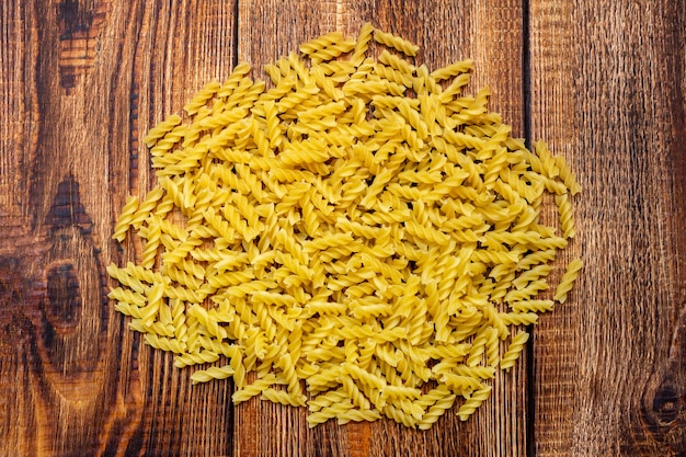 Espaguetis, fusilli, macarrones, pasta en la mesa de madera