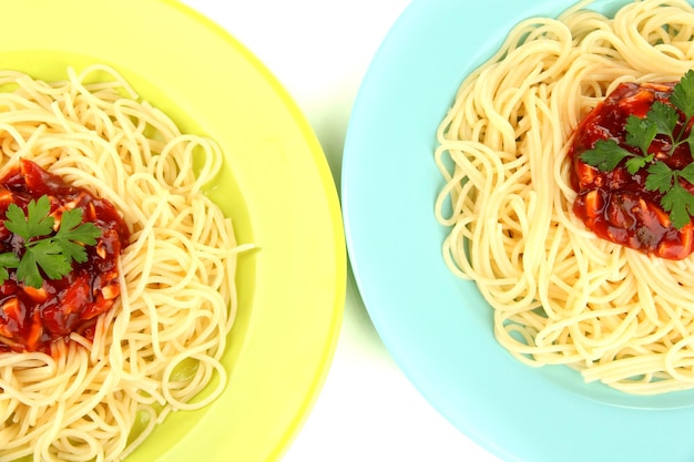 Espaguetis italianos en platos aislados en blanco