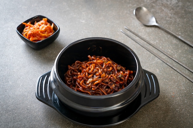 Espaguetis negros coreanos o fideos instantáneos con salsa de soja chajung asada (chapagetti) - estilo de comida coreana