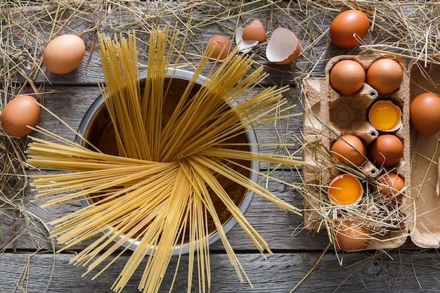 Espaguetis en olla y huevos de gallina frescos