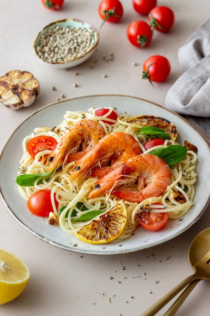 Espaguetis de pasta con camarones, tomates, ajo, espinacas y limón. Cocina italiana. Mariscos. Dieta.
