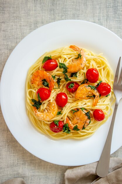 Espaguetis de pasta italiana con camarones y tomates. Cocina nacional.