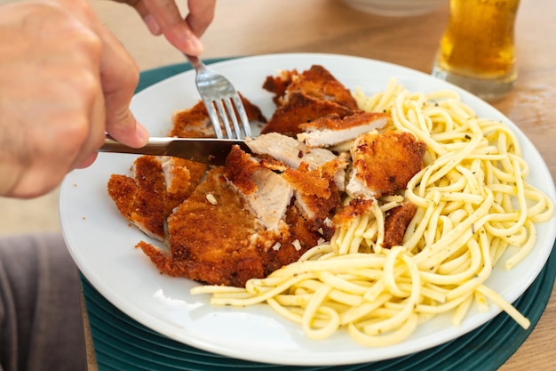 Espaguetis de pasta con pollo frito en plato blanco