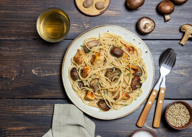 Espaguetis de pasta en salsa cremosa con pollo y champiñones. Comida italiana.