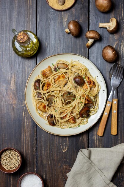 Espaguetis de pasta en salsa cremosa con pollo y champiñones. Comida italiana.