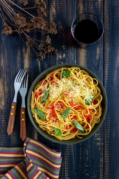 Espaguetis de pasta con tomate, albahaca y queso parmesano. Cocina italiana. Receta. Alimentación saludable.