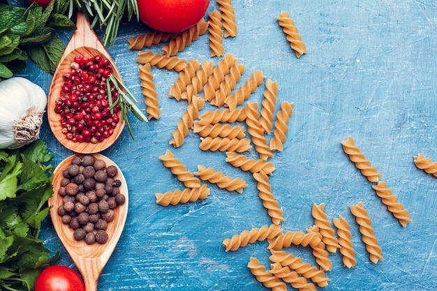 Espaguetis de pasta, verduras y especias, en mesa de madera