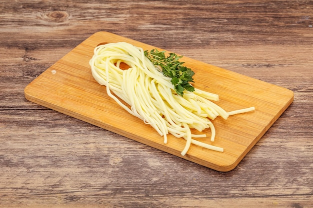 Espaguetis con queso chechil sobre tabla