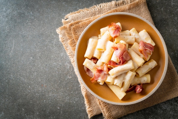 espaguetis rigatoni caseros con salsa blanca y tocino - estilo de comida italiana