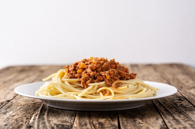 Espaguetis con salsa boloñesa en mesa de madera