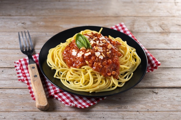 Espaguetis con salsa boloñesa en mesa de madera