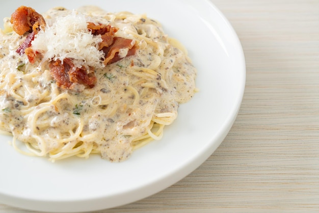 espaguetis con salsa de crema de trufa y champiñones en un plato