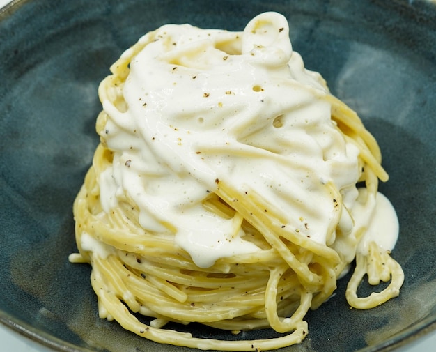 Espaguetis con salsa de cuatro quesos al estilo italiano en un restaurante.