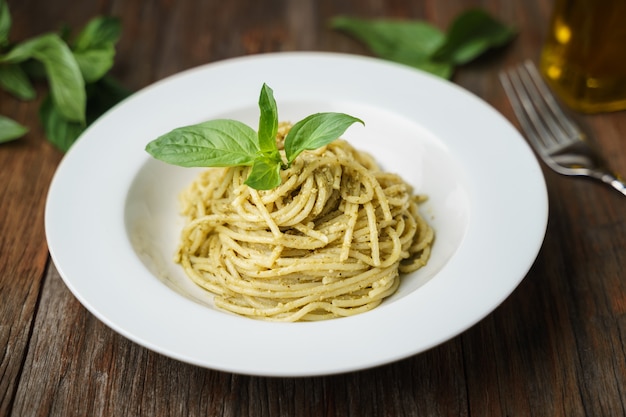 Espaguetis con salsa italiana de pesto en plato blanco