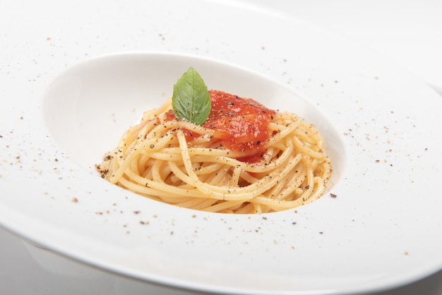 Espaguetis con salsa de tomate, foto en el fondo blanco de cerca