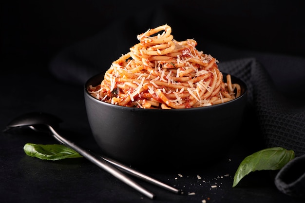 Espaguetis con salsa de tomate y parmesano en tazón negro