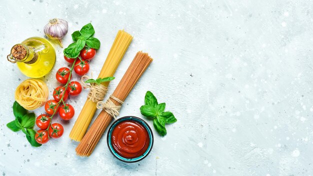 Foto espaguetis secos con albahaca fresca sobre un fondo de piedra gris pasta seca vista superior espacio libre para texto