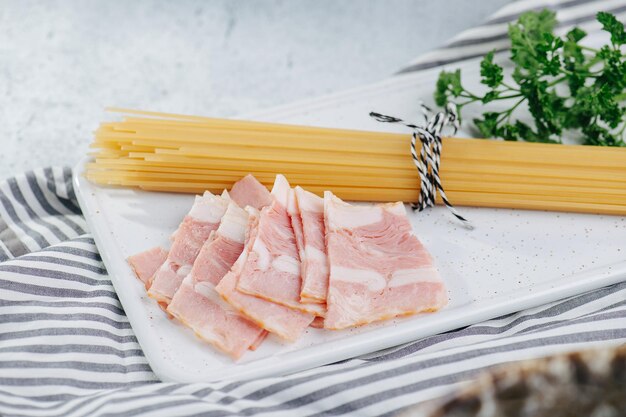 Espaguetis secos de jamón crudo y algunas verduras sobre un paño sobre una mesa