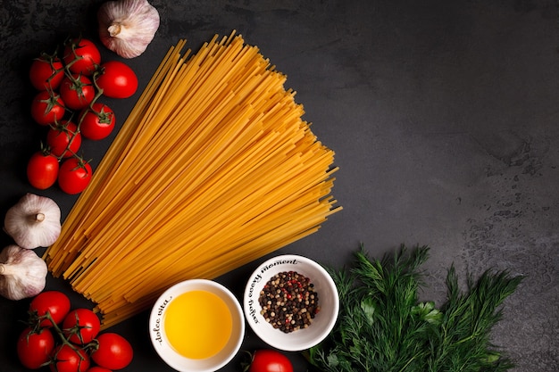 Espaguetis sobre un fondo oscuro. Espaguetis y cereza. Cocinar pasta italiana con verduras