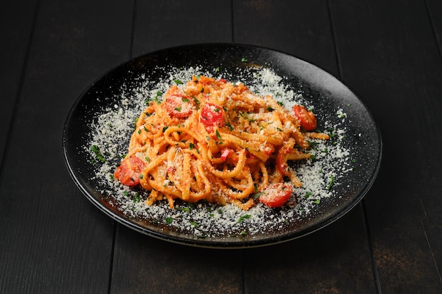 Espaguetis con tomate cherry y parmesano rallado en un plato